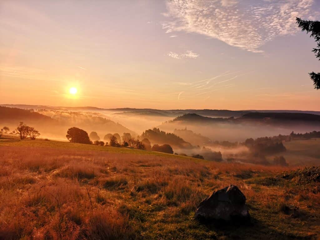 Eine herbstliche, Sonnenaufgangsstimmung mit Nebel in einer Mittelgebirgslandschaft
